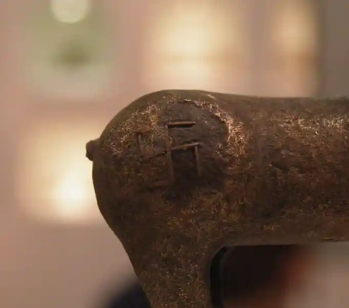 A swastika symbol on the upper part of the back legs of a deer figurine